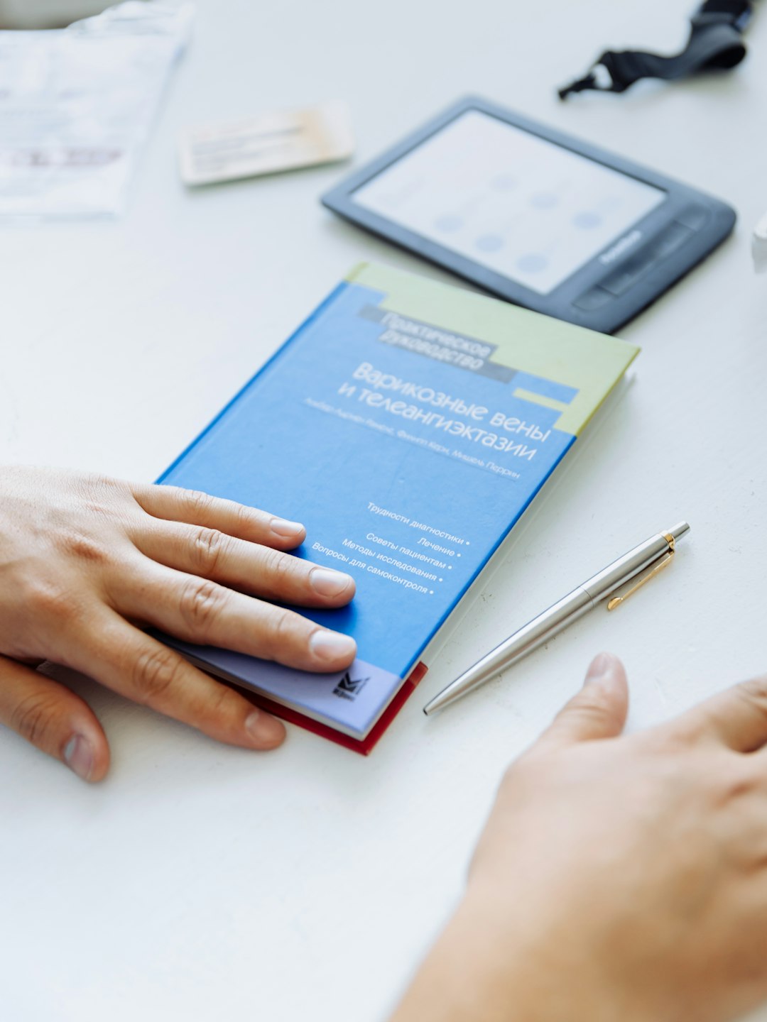 services-03 a-persons-hand-on-a-blue-folder-next-to-a-tablet-innu-y-voc